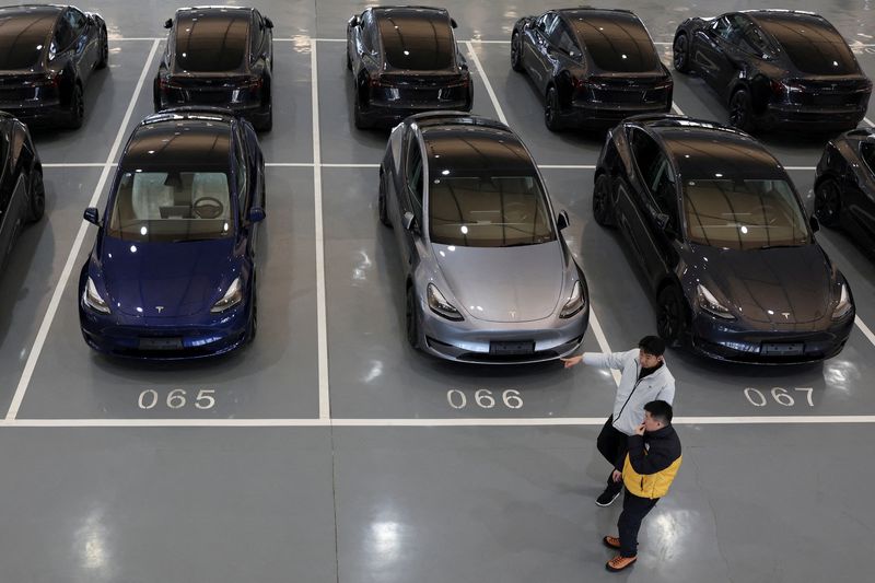 &copy; Reuters. FILE PHOTO: People walk past Tesla electric vehicles (EV) at the carmaker's delivery centre in Beijing, China January 8, 2025. REUTERS/Florence Lo/File Photo