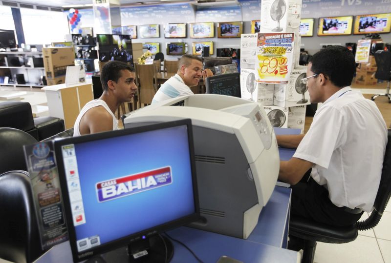 &copy; Reuters. Consumidores conversam com vendedor em loja da Casas Bahia em São Paulon18/02/2013 REUTERS/ Nacho Doce