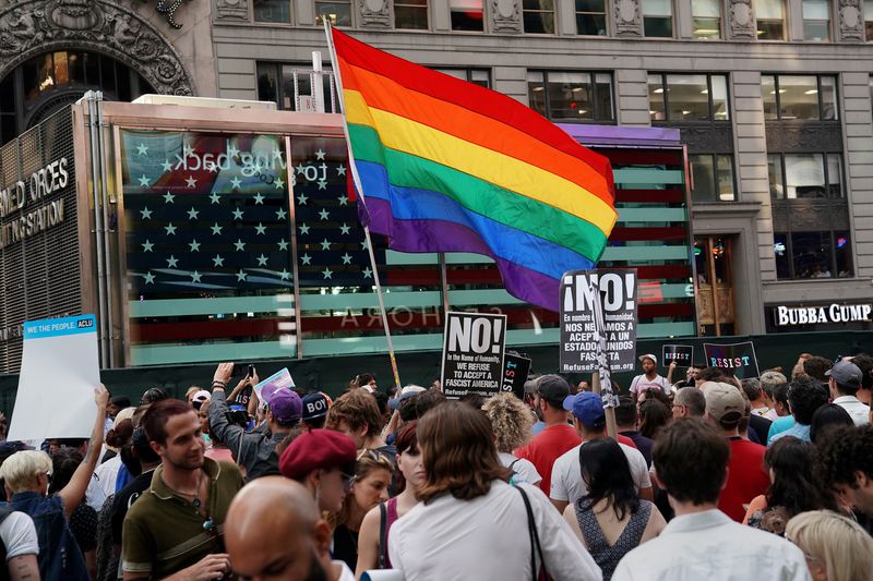 &copy; Reuters. FILE PHOTO: A rainbow flag flies as people protest U.S. President Donald Trump's announcement that he plans to reinstate a ban on transgender individuals from serving in any capacity in the U.S. military, in Times Square, in New York City, New York, U.S.,