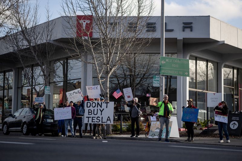 &copy; Reuters. Moradores protestam contra o papel de Elon Musk no governo do presidente dos EUA, Donald Trump, do lado de fora de uma concessionária da Tesla em Palo Alto, Califórnia, Estados Unidosn05/03/2025nREUTERS/Carlos Barria