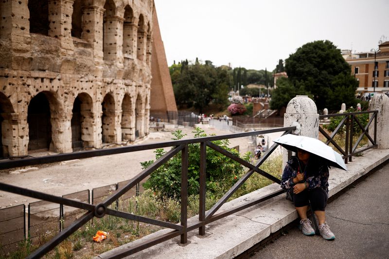 &copy; Reuters. Turista se protege do sol sentada perto do Coliseu em meio a uma onda de calor em Roma, Itálian20/06/2024nREUTERS/Guglielmo Mangiapane