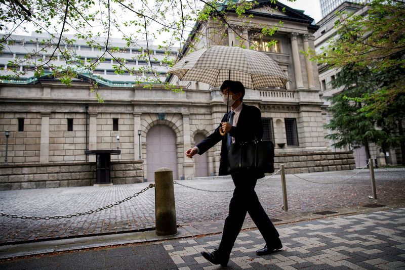 © Reuters. FILE PHOTO: FILE PHOTO: An office employee walks in front of the bank of Japan building in Tokyo, Japan, April 7, 2023. REUTERS/Androniki Christodoulou/File Photo/File Photo