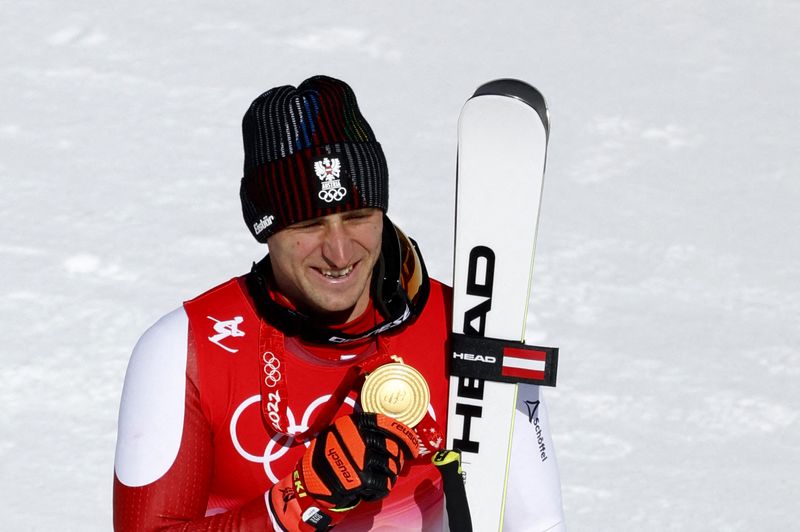 © Reuters. En décrochant une quatrième médaille olympique, l'Autrichien de 31 ans est devenu le troisième skieur alpin titré dans trois éditions différentes après Kjetil Andre Aamodt et Deborah Compagnoni. /Photo prise le 8 février 2022/REUTERS/Thomas Peter