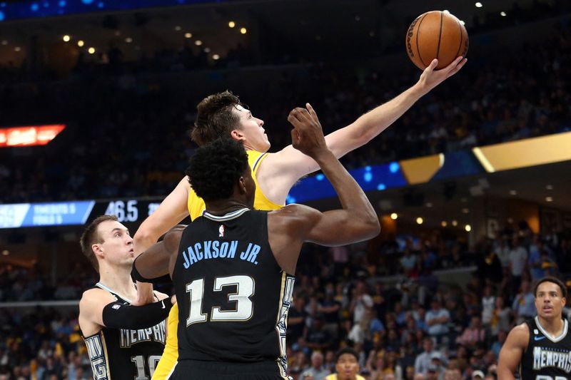 © Reuters. Austin Reaves au duel avec Jaren Jackson Jr.  /Photo prise le 20 avril 2023/REUTERS/USA TODAY USPW